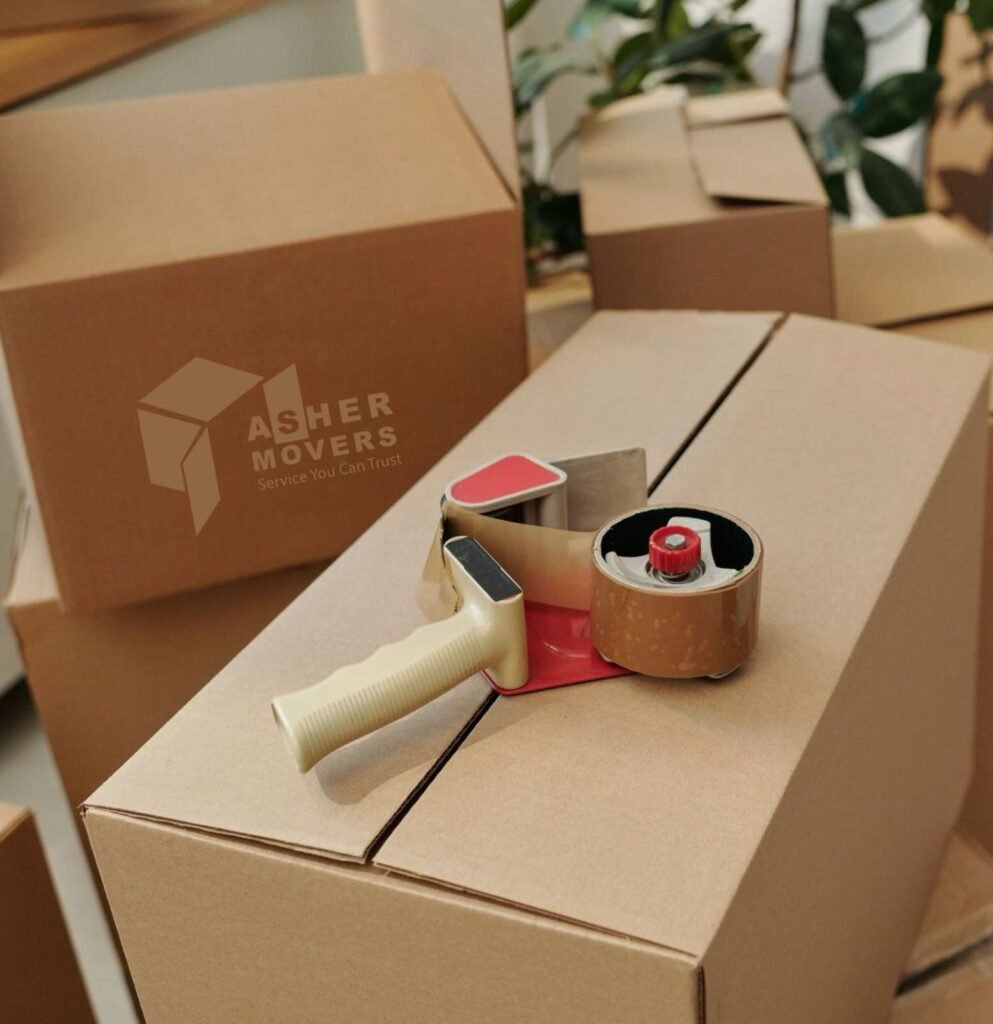 Packing tape dispenser placed on sealed cardboard moving boxes prepared for safe home or office relocation